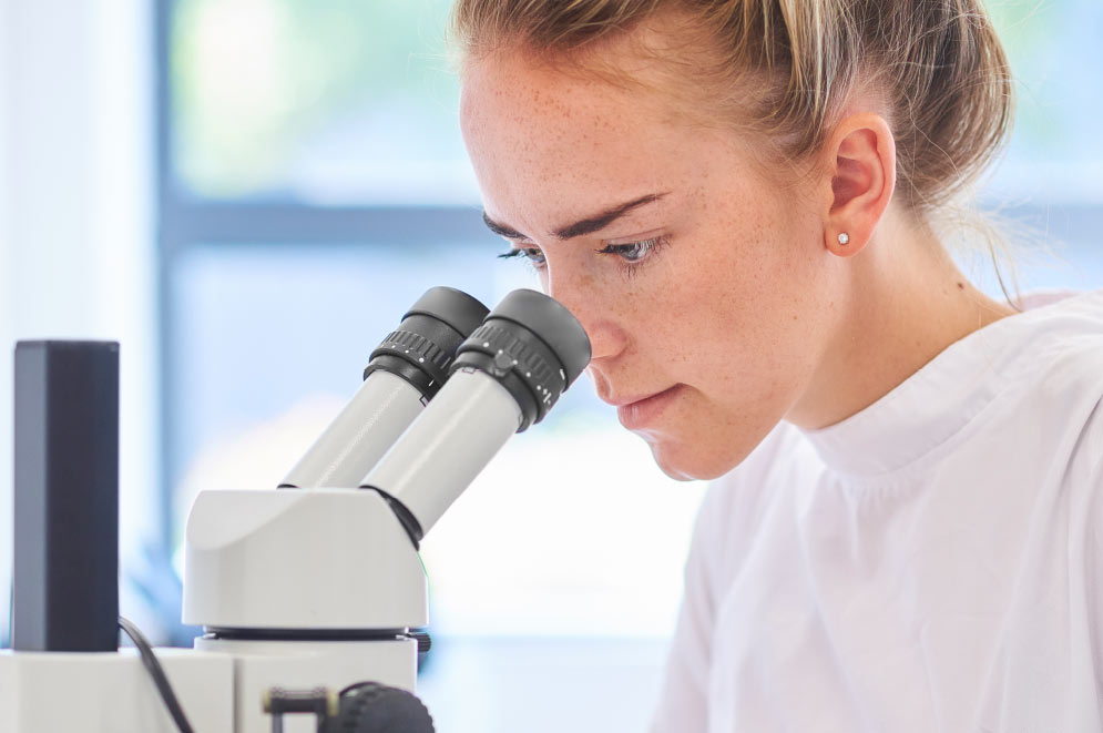 Woman looking into microscope